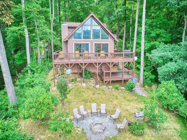 171 Jade Dr, Clyde, NC 28721 - rear view of property featuring a wooden deck, a fire pit, a chimney, and a wooded view