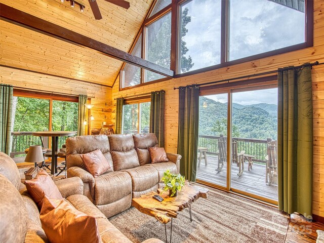 171 Jade Dr, Clyde, NC 28721 - living area with wooden walls, a mountain view, beamed ceiling, a ceiling fan, and wood finished floors