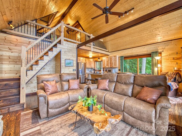 171 Jade Dr, Clyde, NC 28721 - living area with wooden walls, high vaulted ceiling, wooden ceiling with exposed beams, ceiling fan, and stairs