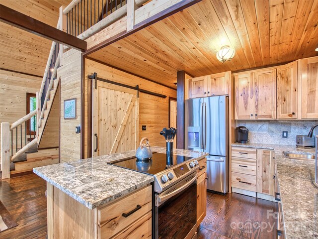 171 Jade Dr, Clyde, NC 28721 - kitchen with appliances with stainless steel finishes, light brown cabinetry, a sink, a barn door, and wooden walls