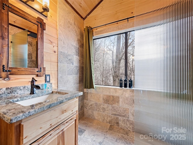 171 Jade Dr, Clyde, NC 28721 - bathroom featuring vanity, lofted ceiling, and stone finish flooring
