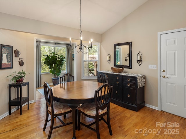 dining space with baseboards, lofted ceiling, a notable chandelier, and light wood-style flooring