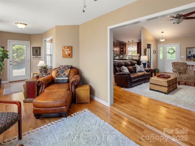 sitting room with hardwood / wood-style flooring, baseboards, and a ceiling fan