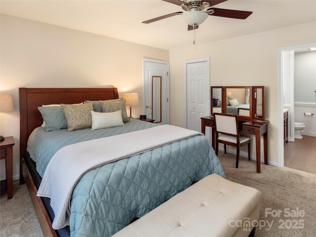carpeted bedroom featuring a ceiling fan, baseboards, and connected bathroom