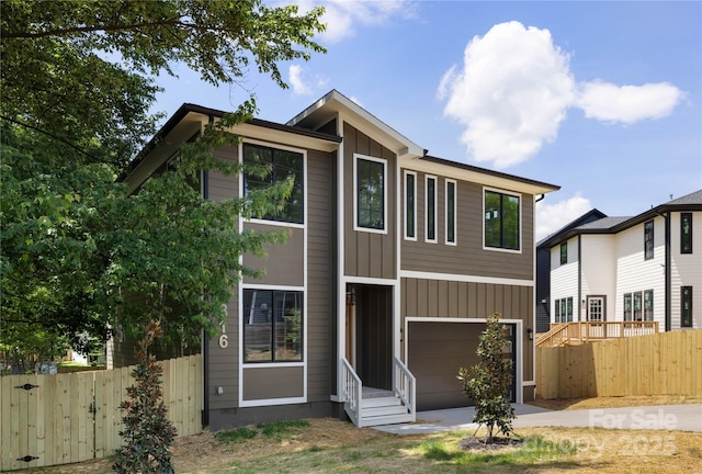 816 Tennyson Dr, Charlotte, NC 28208 - contemporary home featuring a garage, concrete driveway, fence, board and batten siding, and entry steps