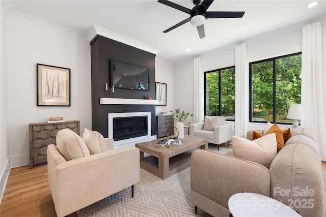 816 Tennyson Dr, Charlotte, NC 28208 - living area with a ceiling fan, crown molding, wood finished floors, a glass covered fireplace, and recessed lighting