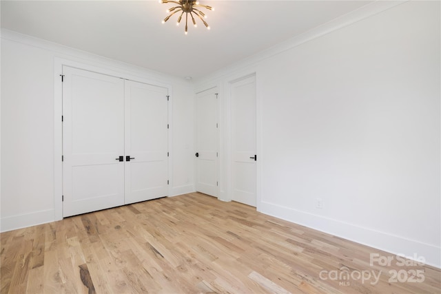 816 Tennyson Dr, Charlotte, NC 28208 - unfurnished bedroom featuring crown molding, baseboards, an inviting chandelier, and light wood-style flooring