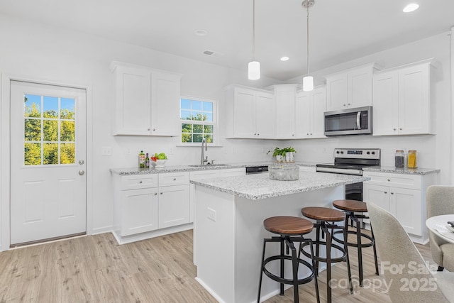 1619 Martin Ave, Gastonia, NC 28052 - kitchen featuring appliances with stainless steel finishes, a sink, a kitchen island, white cabinets, and recessed lighting