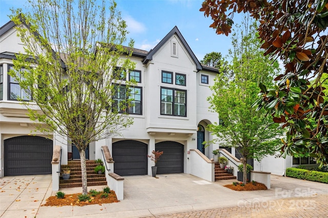 view of front of property with driveway, stucco siding, and a garage