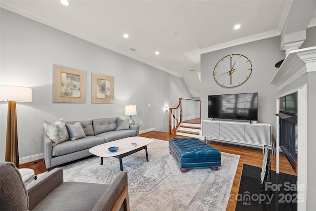 living area featuring stairway, wood finished floors, crown molding, and recessed lighting