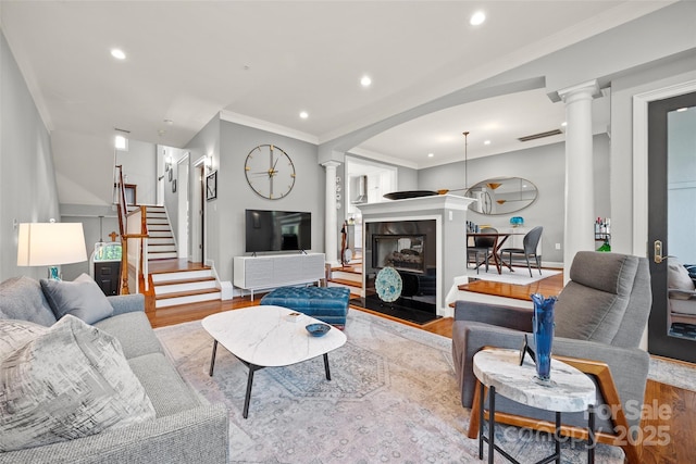 living room with ornate columns, wood finished floors, and recessed lighting