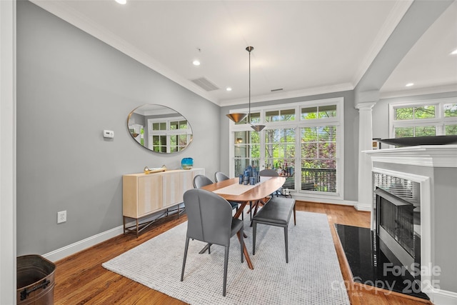 dining area featuring crown molding, baseboards, recessed lighting, a fireplace, and wood finished floors