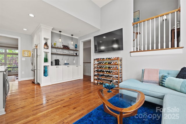 living area with light wood-type flooring, recessed lighting, and baseboards