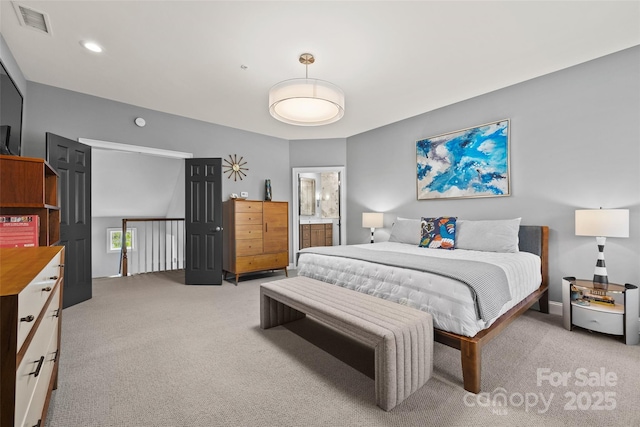 bedroom featuring visible vents, ensuite bathroom, and carpet floors