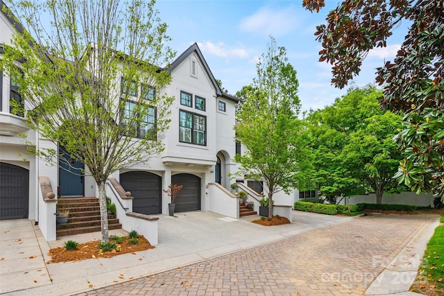 view of front of property featuring a garage, stucco siding, and decorative driveway