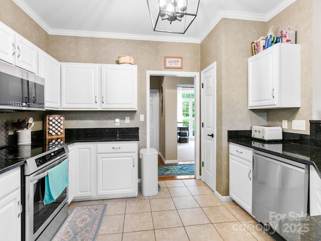 kitchen with appliances with stainless steel finishes, ornamental molding, a chandelier, and white cabinets