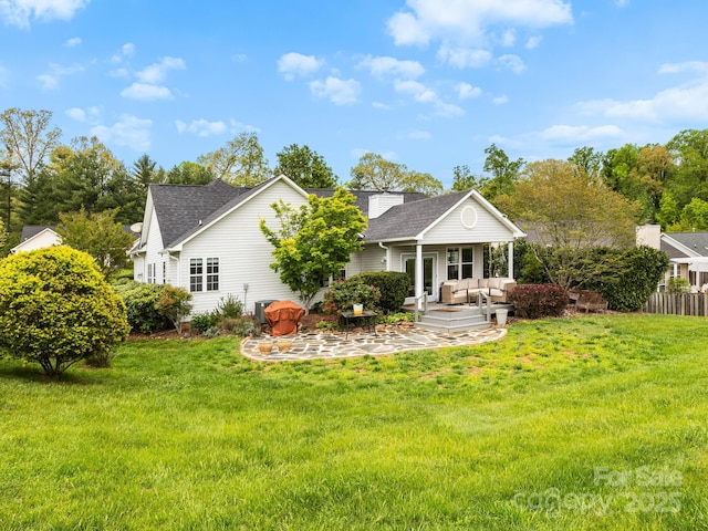 back of house featuring a patio area, a shingled roof, a yard, and outdoor lounge area