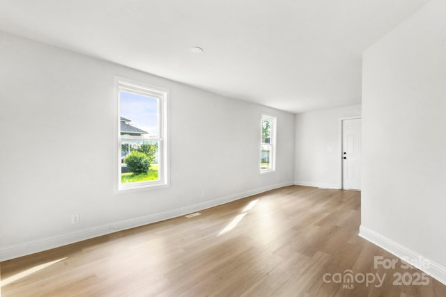 empty room with baseboards and wood finished floors