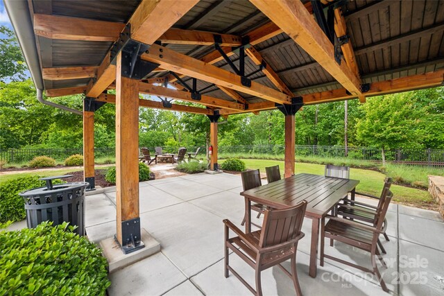528 Rock Skip Way, Fort Mill, SC 29708 - fenced backyard with outdoor dining space, a fire pit, a patio, a gazebo, and view of wooded area