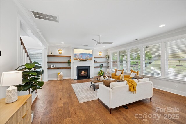 528 Rock Skip Way, Fort Mill, SC 29708 - living room featuring a ceiling fan, ornamental molding, wood finished floors, a fireplace with flush hearth, and stairs