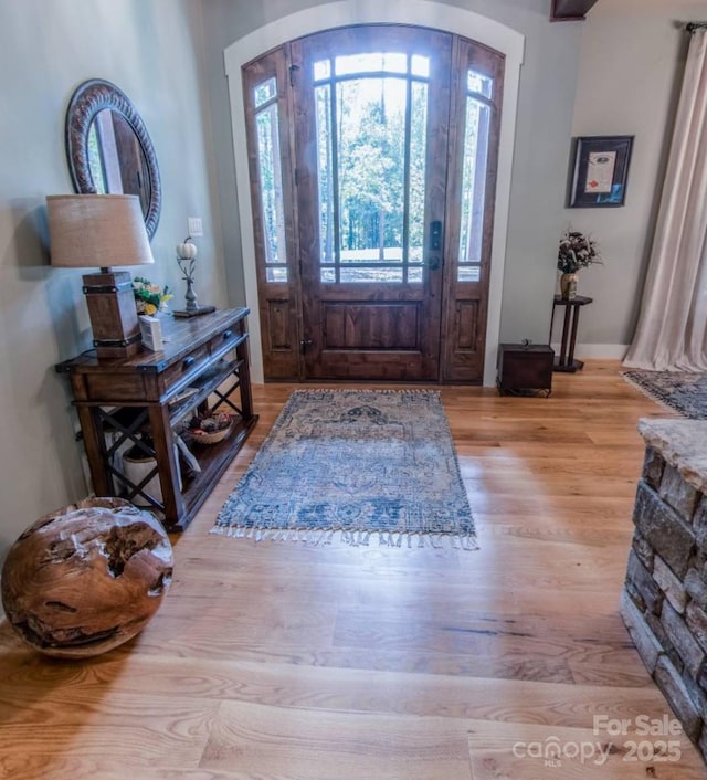 entryway with plenty of natural light, wood finished floors, and arched walkways