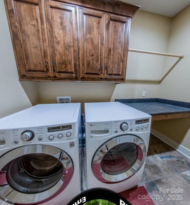 clothes washing area with cabinet space, washer and dryer, and baseboards