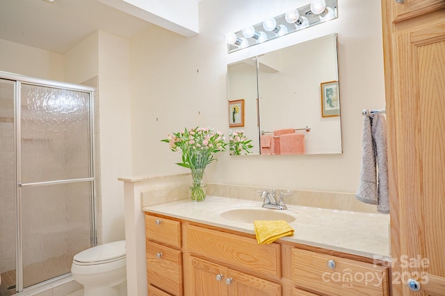 bathroom featuring vanity, tile patterned flooring, a shower stall, and toilet