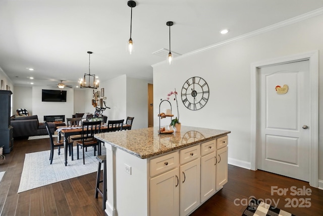 4321 Hornyak Dr, Monroe, NC 28110 - kitchen featuring dark wood finished floors, a kitchen island, hanging light fixtures, a ceiling fan, and ornamental molding