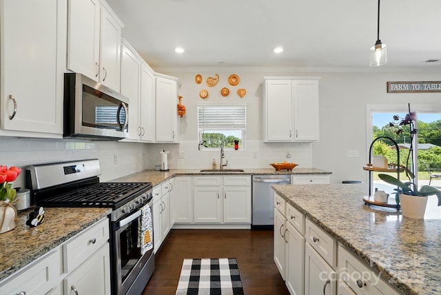 4321 Hornyak Dr, Monroe, NC 28110 - kitchen with appliances with stainless steel finishes, a sink, crown molding, white cabinets, and backsplash