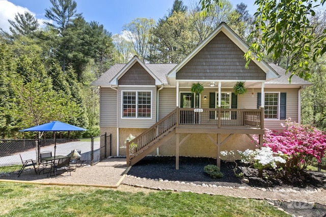 back of property featuring stairway, a porch, fence, and a shingled roof