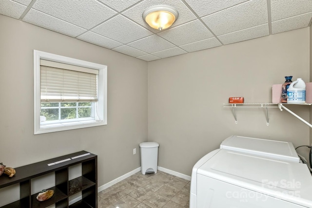 washroom featuring washing machine and clothes dryer, laundry area, and baseboards