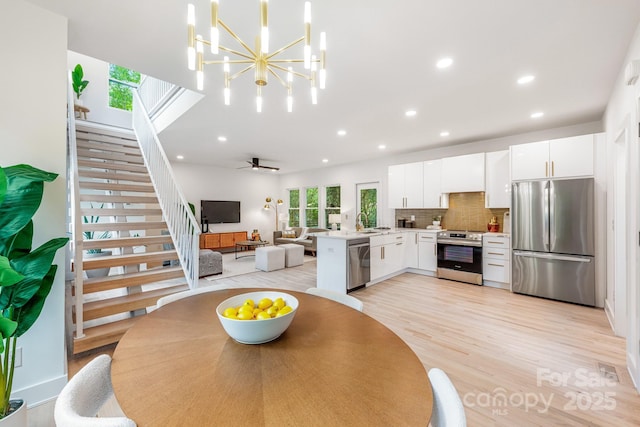 1847 Vinton St, Charlotte, NC 28216 - dining area featuring a notable chandelier, light wood-style flooring, stairs, and recessed lighting