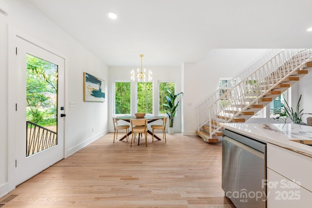 1847 Vinton St, Charlotte, NC 28216 - dining room featuring a chandelier, baseboards, light wood finished floors, and stairs