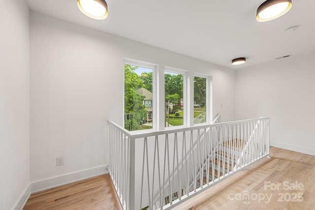 1847 Vinton St, Charlotte, NC 28216 - hallway featuring wood finished floors, visible vents, baseboards, and an upstairs landing