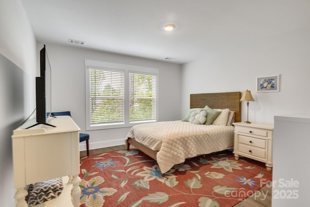 bedroom featuring visible vents, baseboards, and dark wood-style floors