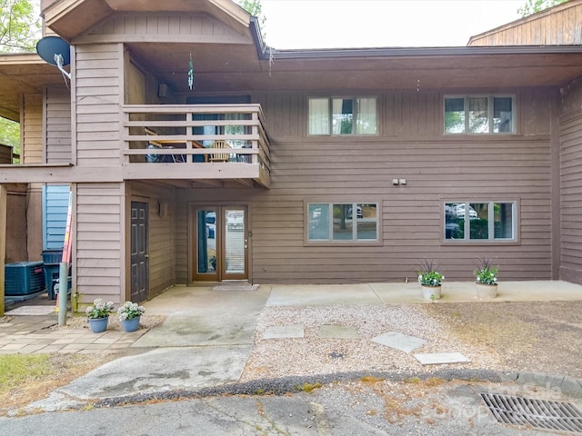back of property featuring central AC unit and a balcony