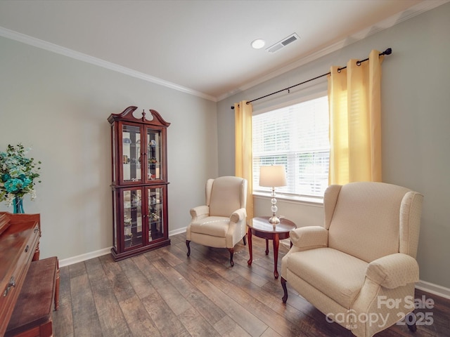 sitting room featuring crown molding, baseboards, wood-type flooring, and visible vents