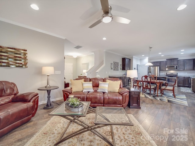 living area featuring visible vents, ornamental molding, wood-type flooring, recessed lighting, and a ceiling fan