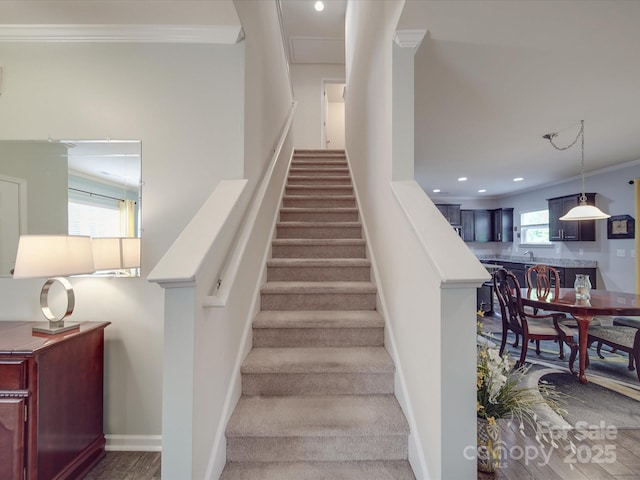 stairway featuring recessed lighting, ornamental molding, baseboards, and wood finished floors
