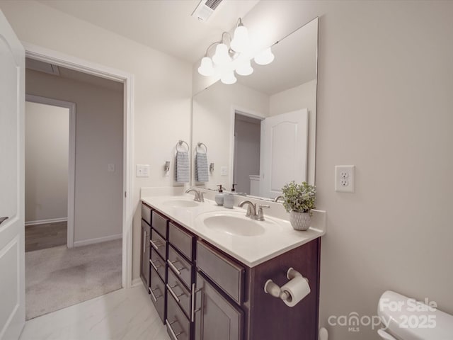bathroom with double vanity, toilet, visible vents, and a sink