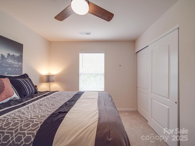 carpeted bedroom with ceiling fan, visible vents, baseboards, and a closet