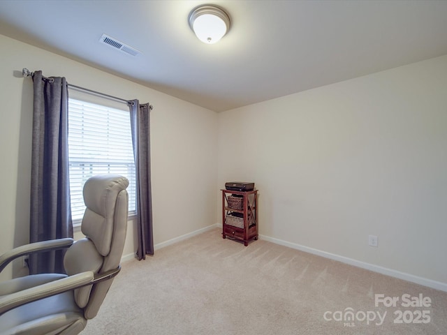 office space with baseboards, visible vents, and light carpet