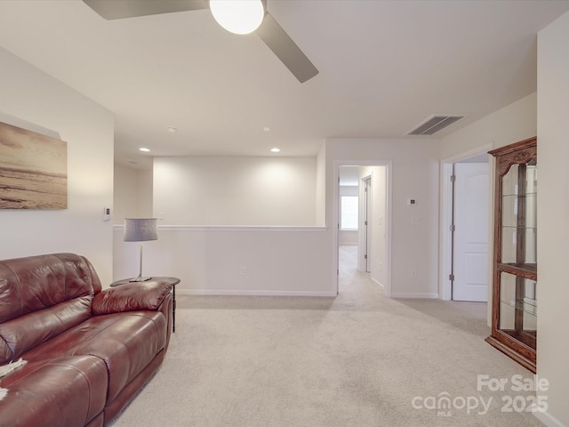 living area featuring ceiling fan, light colored carpet, baseboards, and visible vents