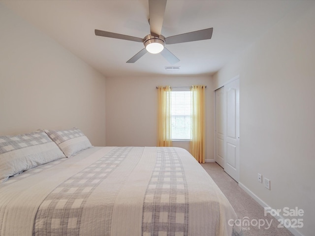 bedroom with baseboards, ceiling fan, visible vents, and light colored carpet