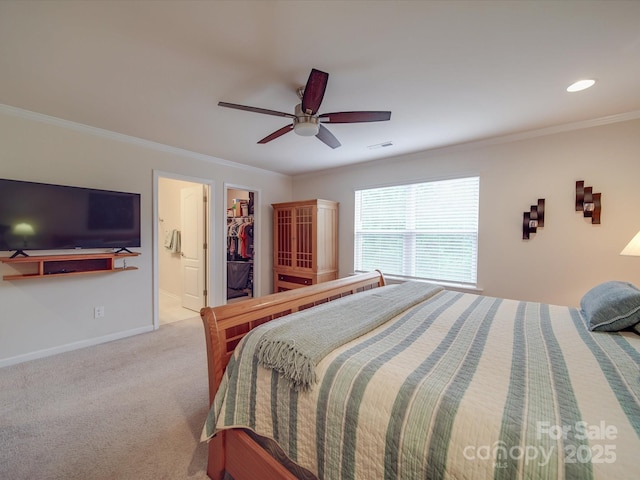 bedroom featuring crown molding, carpet, baseboards, a spacious closet, and visible vents