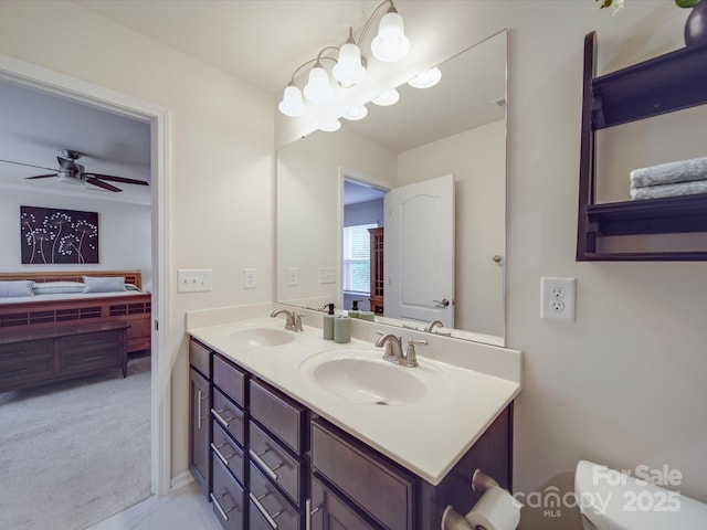 bathroom with double vanity, a sink, ceiling fan, and toilet