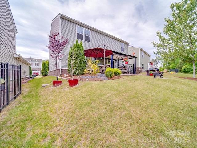 rear view of property featuring a lawn and a gazebo