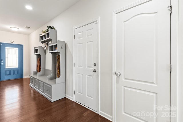 mudroom featuring baseboards, visible vents, and dark wood-type flooring
