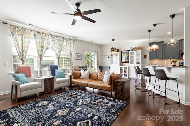 living area with baseboards, ceiling fan, dark wood-style floors, and visible vents