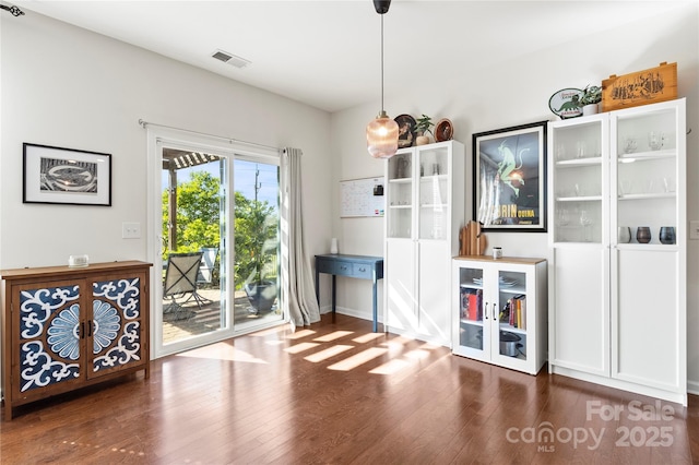 interior space with visible vents, baseboards, and wood finished floors